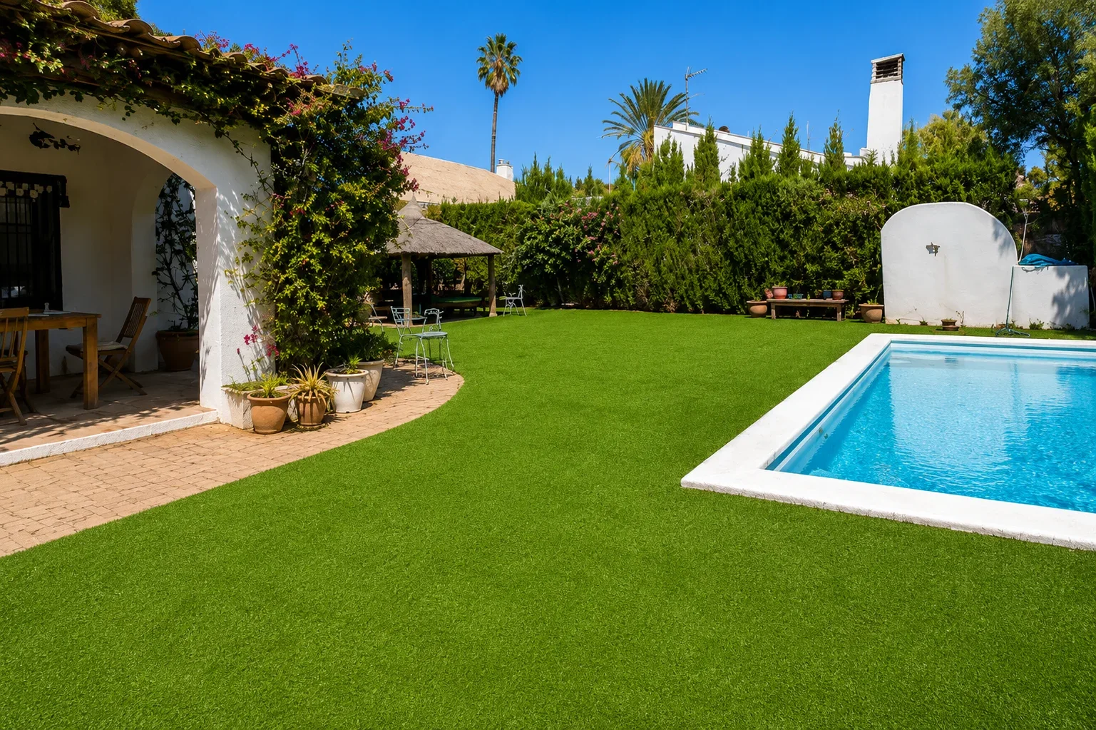 Zona de estar cubierta con césped artificial junto a la piscina en Calpe